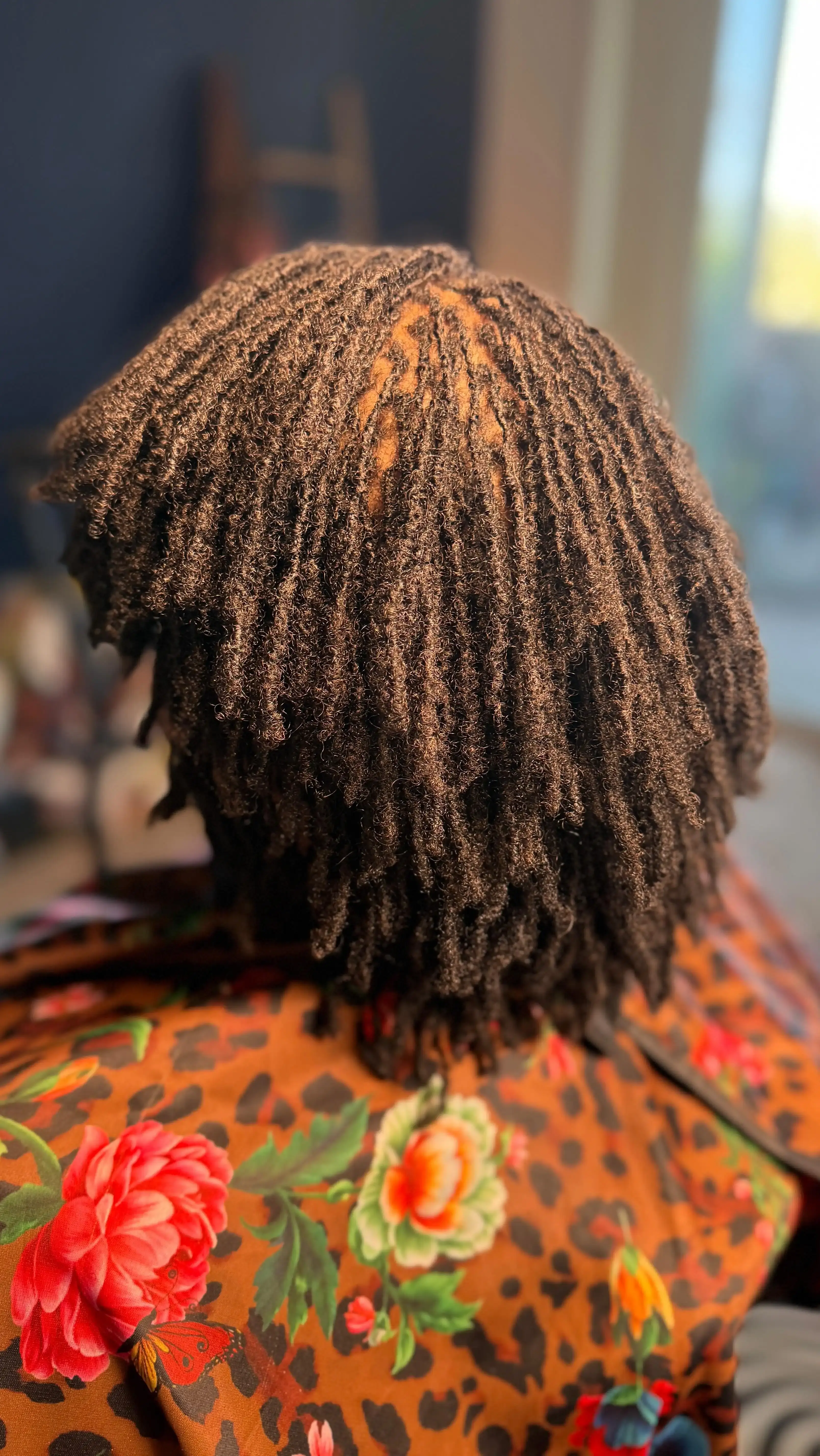 Client showcasing beautifully maintained starter locs with golden highlights