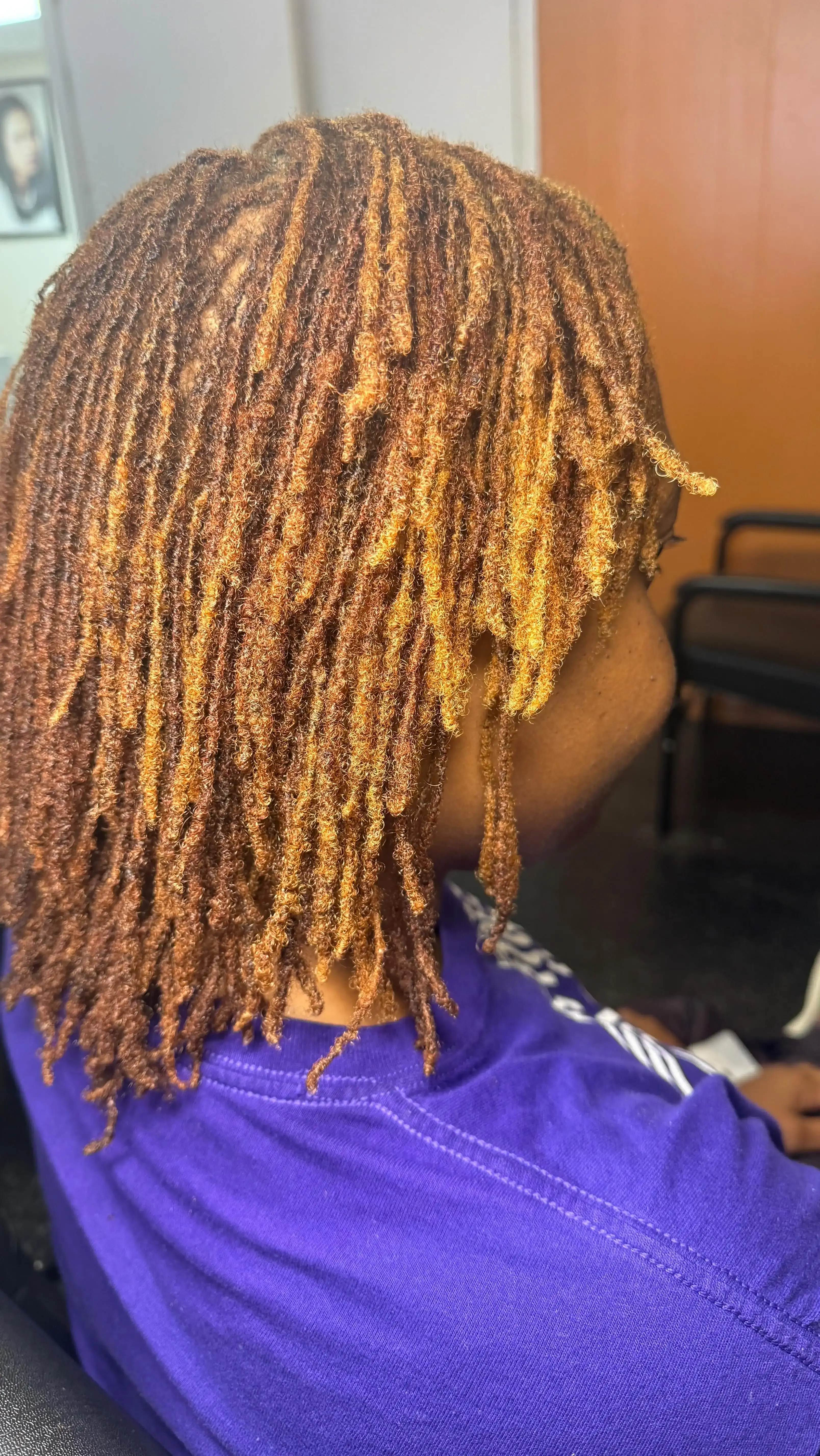 Shoulder-length golden-brown locs styled with natural movement and shine