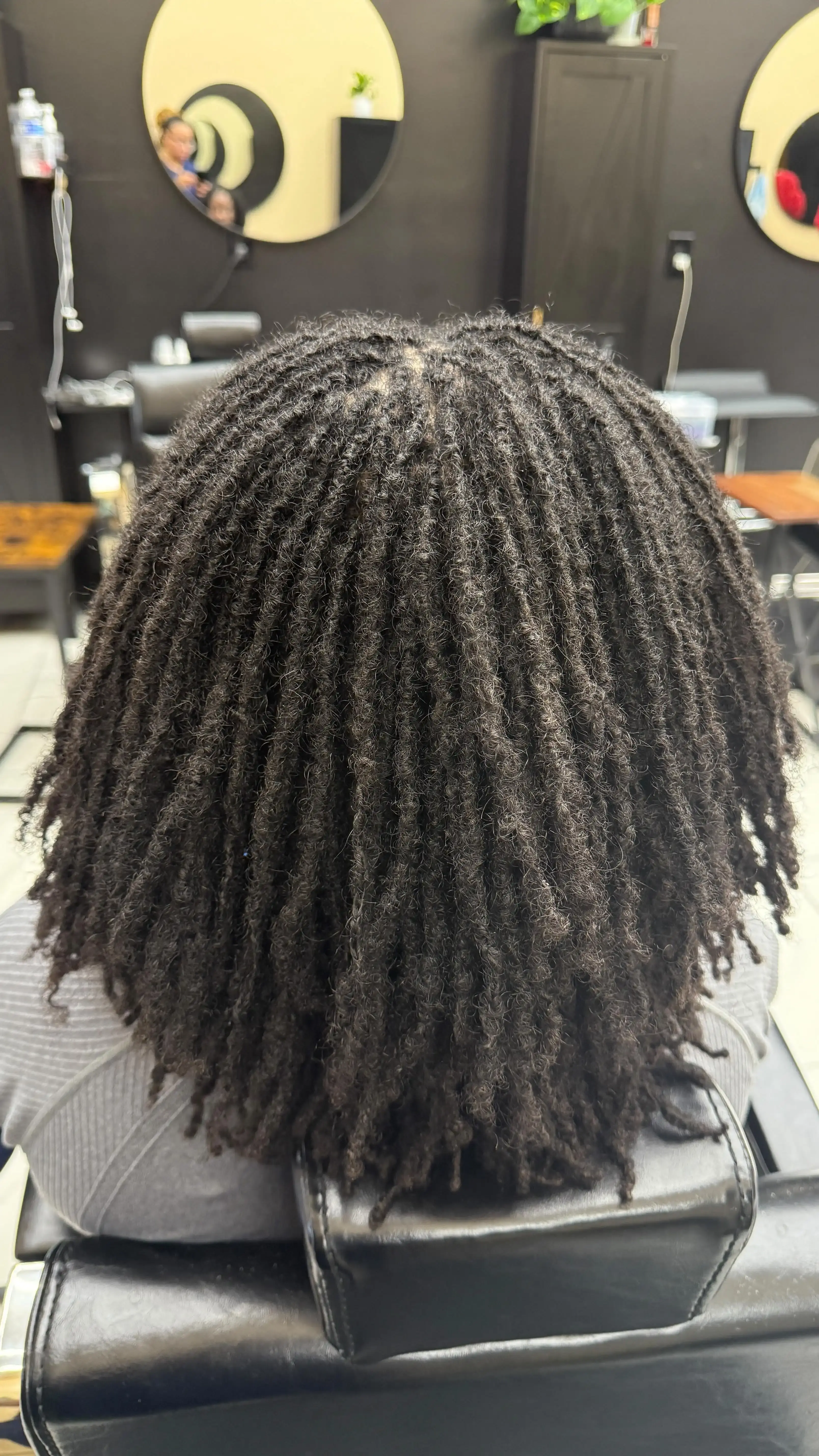 Client relaxing in salon chair showcasing healthy loc maintenance results