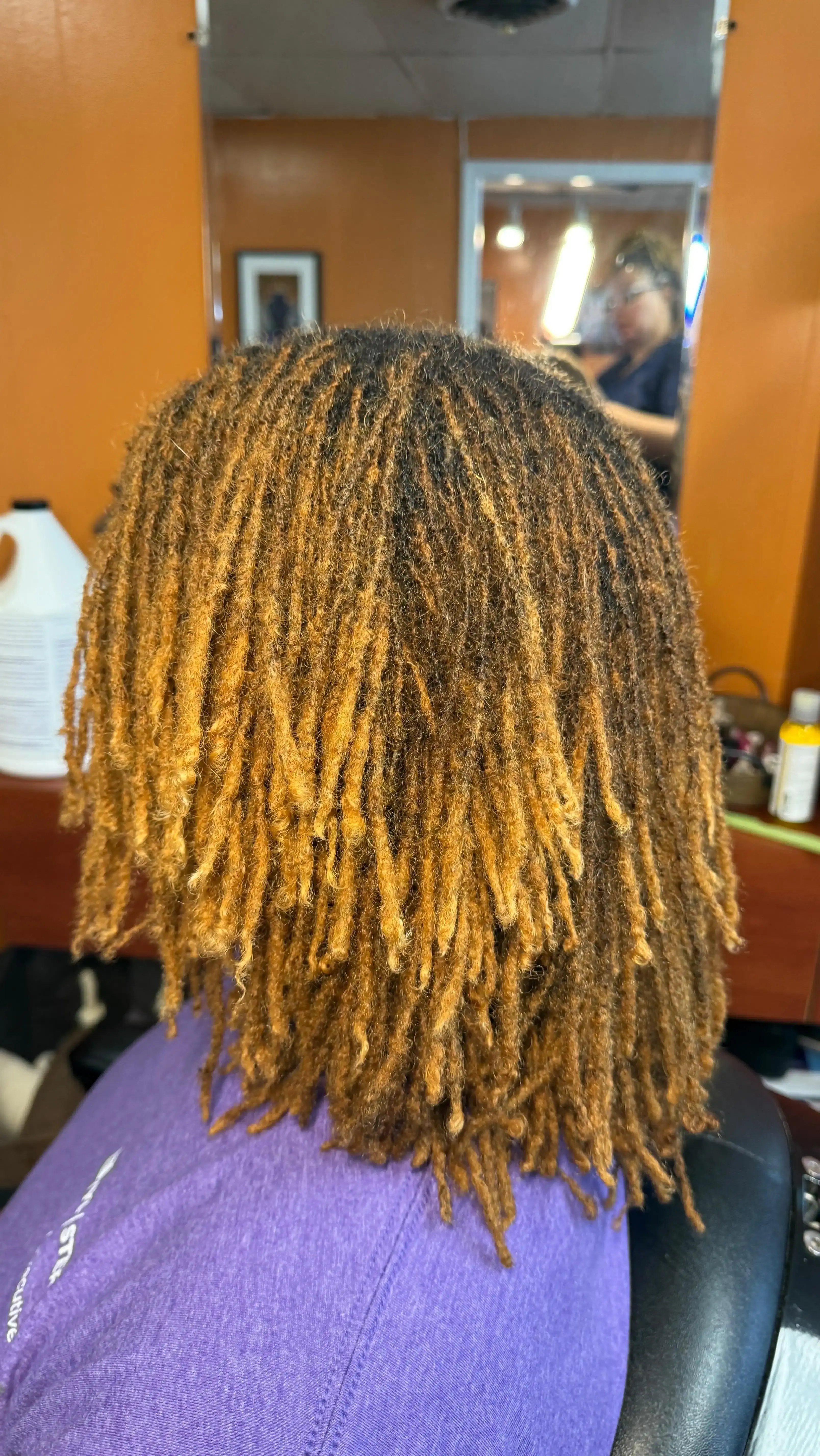 Warm honey-toned locs with professional styling and healthy hair definition